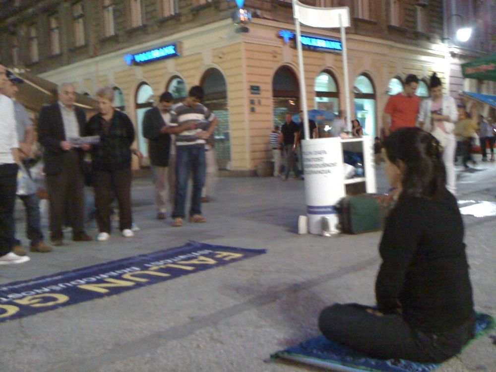 Prolaznici posmatraju Falun Gong vježbe.