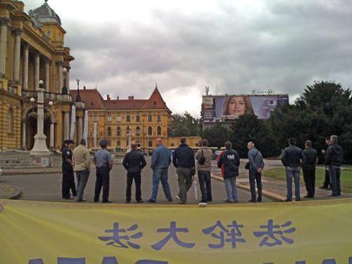 Kordon policajaca pokušava da zakloni pogled na Falun Gong praktikante